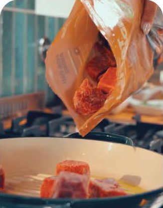 Cubos de carne congelada a cair da embalagem para um tacho